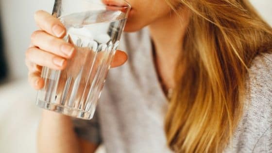 Image of a woman drinking water before a meal. How to Lose Weight Safely for Teens - 8 Steps